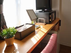 a desk with a computer and a television on it at Pod Select Hotel Shinjuku in Tokyo
