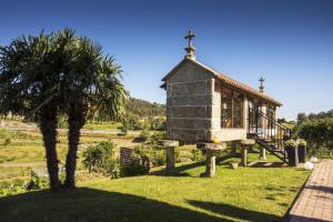 una pequeña casa con una palmera en el patio en Quinta de San Amaro Rias Baixas, en Meaño
