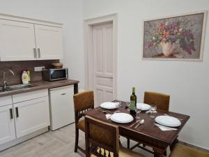 a kitchen with a wooden table with chairs and a dining room at TulipánVendégház in Keszthely