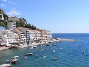 a group of boats in a body of water with buildings at Hotel Obala in Budva