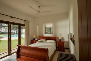 a bedroom with a bed and a large window at The Beach Villas by Ceylon Bungalows in Wadduwa +44 photos
