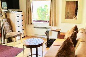 a living room with a couch and a table and a window at Scottish Border Powfoot Dumfries in Annan