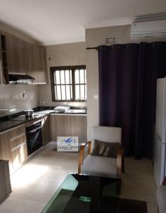 a kitchen with a couch and a chair in a room at bedroomed fully furnished apartment Near East Park Mall in Kabulonga
