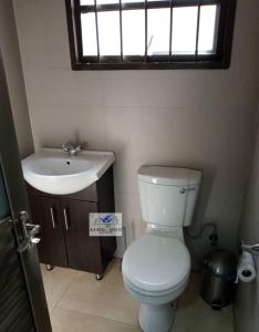 a bathroom with a toilet and a sink and a window at bedroomed fully furnished apartment Near East Park Mall in Kabulonga