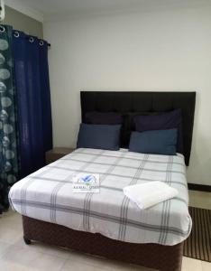a bed with two towels on it in a room at bedroomed fully furnished apartment Near East Park Mall in Kabulonga
