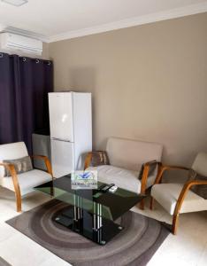 a living room with a glass table and chairs at bedroomed fully furnished apartment Near East Park Mall in Kabulonga