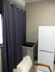 a room with a refrigerator and a table and a chair at bedroomed fully furnished apartment Near East Park Mall in Kabulonga