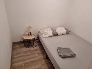 - un lit avec deux oreillers et une lampe sur une table dans l'établissement logis 149, à Gruissan