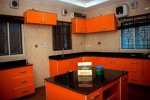 une cuisine avec des armoires orange et un comptoir noir dans l'établissement Room in Lodge - Mexiloyd Luxury Rooms Suites, à Port Harcourt
