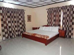 Een bed of bedden in een kamer bij Room in Lodge - Lotus Hotels and Suites