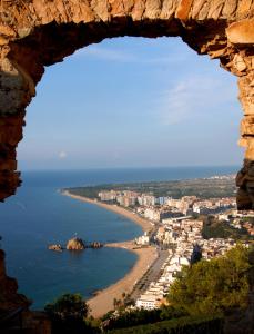 a view of a beach through a window at Camping Sabanell in Blanes
