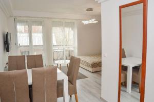 ein Wohnzimmer mit einem Tisch und Stühlen sowie ein Schlafzimmer in der Unterkunft Héli apartman in Hajdúszoboszló