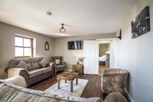 ein Wohnzimmer mit einem Sofa und einem Tisch in der Unterkunft The Beacon - 3 Bedroom Cottage - Ludchurch - Narberth in Ludchurch