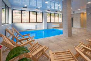 a pool with lounge chairs and a swimming pool at Chalet ForREST in Arkhyz