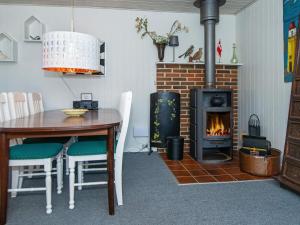 a dining room with a table and a fireplace at 6 person holiday home in Hemmet in Hemmet