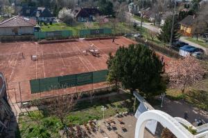 una vista aérea de una pista de tenis con una pista de tenis en Hotel Négy Évszak, en Siófok