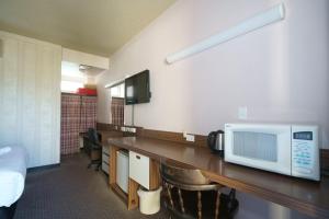 a room with a table with a microwave on it at Olympia Motel in Queanbeyan