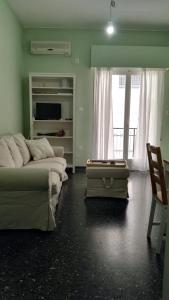 ルートラキにあるParis Spacious Beach Apartmentのベッド2台、ソファ、椅子が備わる客室です。