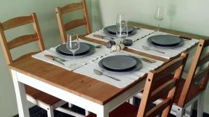ルートラキにあるParis Spacious Beach Apartmentの木製テーブル(皿、ワイングラス付)