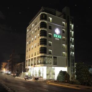 a tall building with a from sign on it at night at Fiori Hotel in Erbil