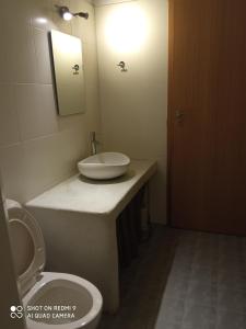 W łazience znajduje się umywalka, toaleta i lustro. w obiekcie elaiolithos w mieście Kóstos