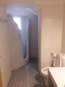 biała łazienka z toaletą i oknem w obiekcie elaiolithos w mieście Kóstos