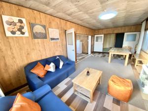 uma sala de estar com um sofá azul e uma mesa em Sola St Inn Noboribetsu 2min walk from Noboribetsu station em Noboribetsu
