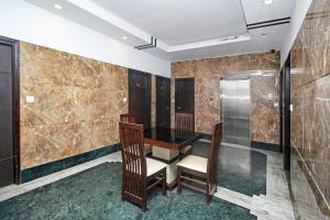 a dining room with a table and chairs and marble walls at FabHotel Arihant Inn in New Delhi