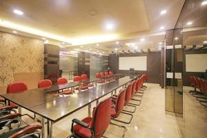 a conference room with a long table and red chairs at FabHotel Arihant Inn in New Delhi