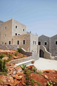 a large brick building with a bench in front of it at Petritis Guesthouse in Neo Itilo