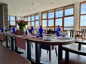 a dining room with a table with blue bottles on it at Landhaus Nordhelle Garni in Meinerzhagen