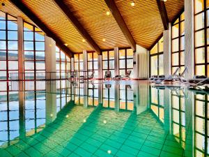 a swimming pool with chairs in a building at Landhaus Nordhelle Garni in Meinerzhagen
