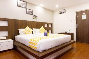 a bedroom with a large bed with a wooden headboard at FabHotel Sholas Residency I in Ooty