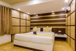 a bedroom with a large white bed and a desk at FabHotel Sholas Residency I in Ooty