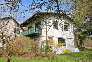 ein weißes Haus mit einem Balkon an der Seite in der Unterkunft Ferienwohnung Verchen SCHW 881 in Verchen