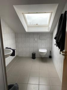 a bathroom with a sink and a toilet with a skylight at Appartement 7 in Hilter in Hilter am Teutoburger Wald