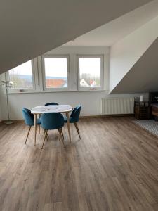 a dining room with a table and chairs and two windows at Appartement 7 in Hilter in Hilter am Teutoburger Wald