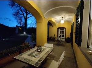 eine Terrasse mit einem Tisch und Stühlen auf einem Haus in der Unterkunft Bed&Breakfast Villa Camilla in Ivrea
