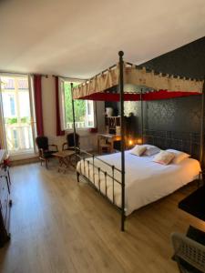 - une chambre avec un lit à baldaquin et un bureau dans l'établissement The Originals Boutique, Hôtel Roca-Fortis, Rochefort, à Rochefort