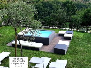a garden with a pool and chairs and a tree at Antica Corte Panego in Negrar