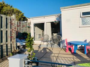 a patio with a blue table and chairs and a fence at Nicolas Devon air bed and breakfast in Ilfracombe