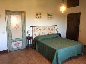 a bedroom with a bed with a green bedspread at Agriturismo Fattoria Di Corsano in Corsano