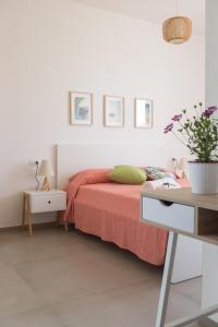 een witte slaapkamer met een bed en een bureau bij Marezè in Punta Secca