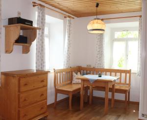 a dining room with a table and chairs and a table and a dresser at Grafn-Hof in Schleching