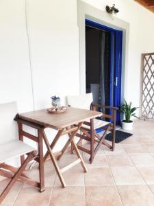 a wooden table and chairs on a patio at Orange Apartments in Vasiliki