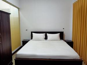 a bedroom with a bed with white sheets and a window at Greenfield Bedz in Hatton