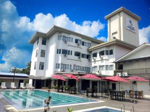 a hotel with a swimming pool in front of a building at Myangkasa Akademi & Resort Langkawi in Pantai Cenang