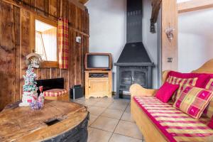 a living room with a couch and a tv at La Grange de Marie in Les Allues