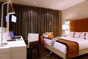 a hotel room with two beds and a desk with a laptop at Holiday Inn Madrid - Las Tablas, an IHG Hotel in Madrid