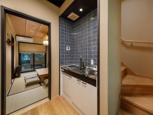a small kitchen with a sink and a mirror at Kanade Fushimiinari-Inometei in Kyoto